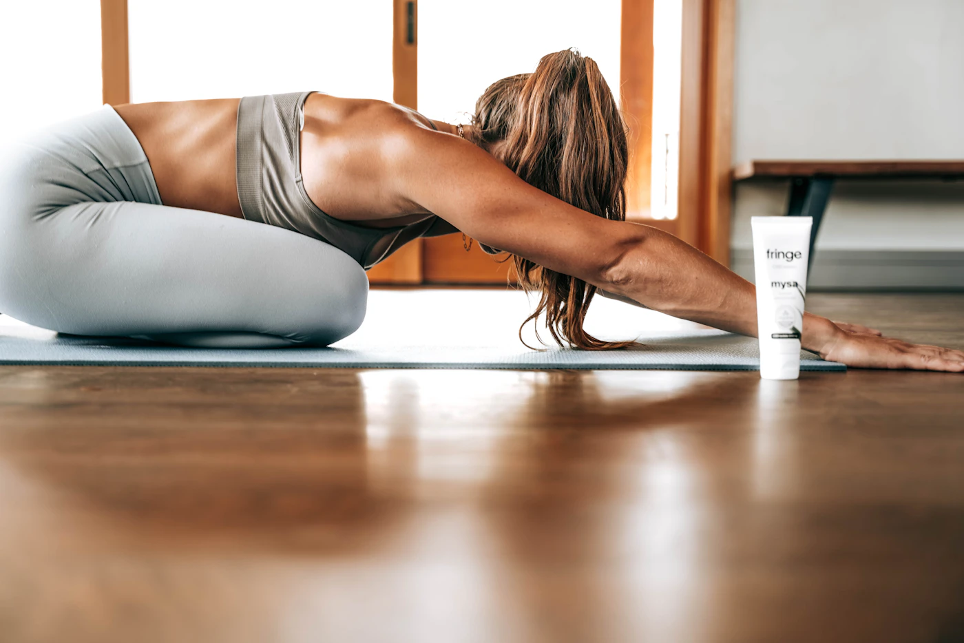 Eine Person praktiziert zu Hause eine traditionelle Hatha-Yoga-Asana auf einem Holzboden